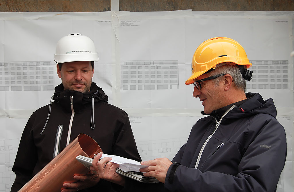 Grundsteinlegung zur Siedlung Erikastrasse: Bauleiter Felix Ruben (links im Bild) und SAW-Projektleiter Joseph D’Aujourd’hui befüllen die Zeitkapsel, die im Fundament einbetoniert wird.